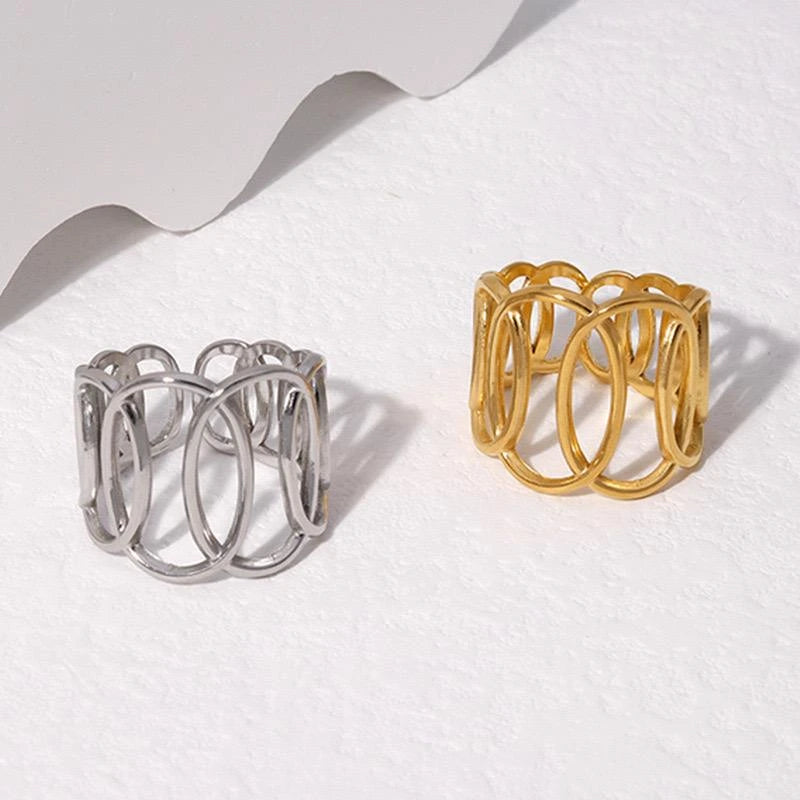 Two metallic rings, one silver and one gold, on a white surface.