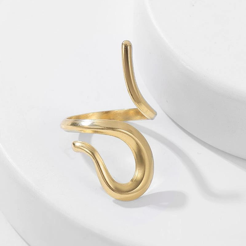 Gold spiral ring on a white fabric background