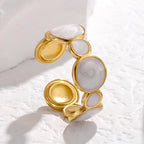 Gold and white stone ring on a textured white surface