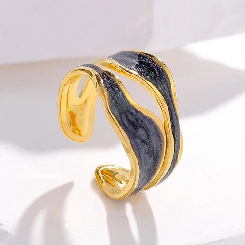 Gold and black marbled cuff ring on a light background