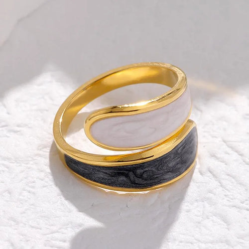 Gold and black spiral ring on a textured white surface