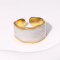 Gold and white ring on a light background