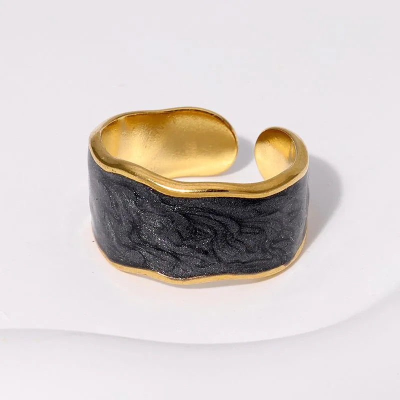 Gold and black marbled cuff ring on a white background