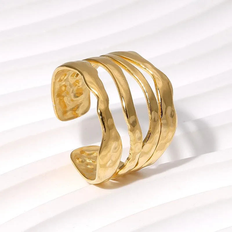 Layered hammered gold ring on a white background