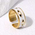 Gold and white ring with black accents on a light background