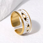 Gold and white ring with black accents on a light background