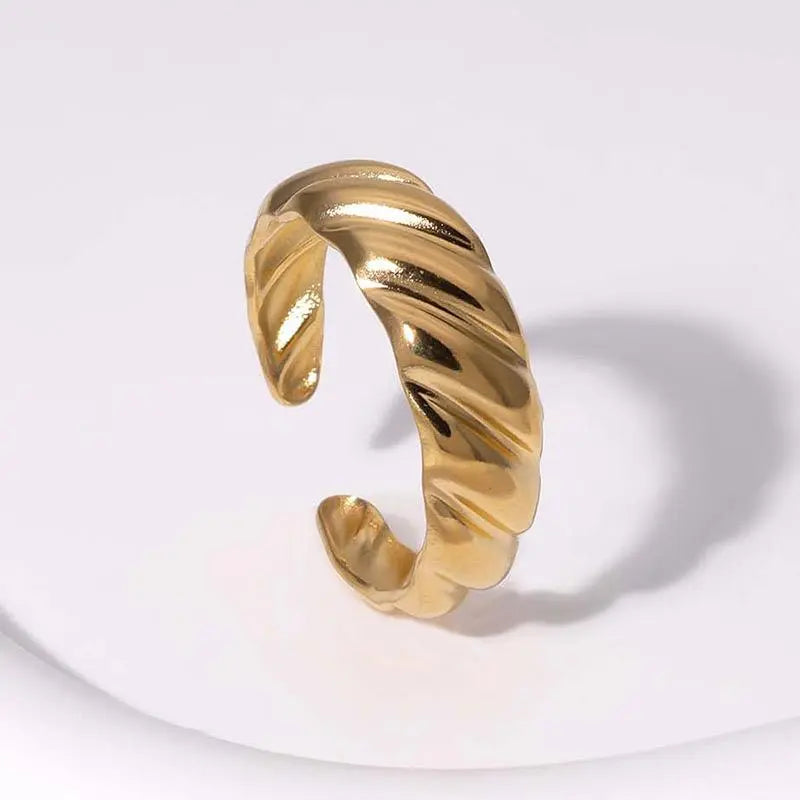 Gold textured ring on a light gray background