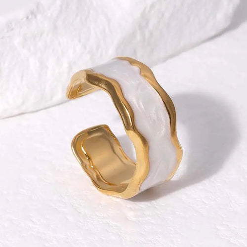 Gold and white ring on a textured white surface